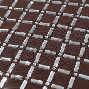 Dettaglio del tessuto a rete marrone con lussuoso motivo geometrico di strass