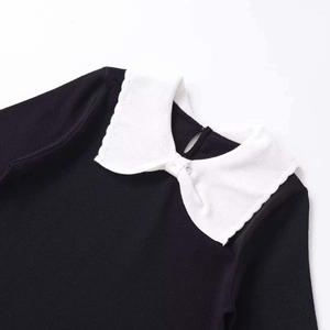 Slim fit black knit top featuring a white Peter Pan collar with a bow knot design