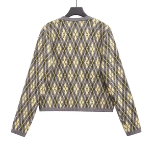 Close-up of argyle knit cardigan featuring yellow green and grey diamond patterns