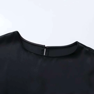Detail of black dress neckline with teardrop cutout and back button closure