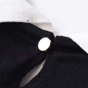 Slim fit knit top with classic black and white contrast design and a single white button