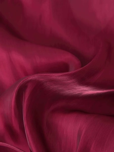 Macro detail of wine red satin fabric with elegant silk luster and fine texture