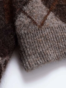 Close-up of diamond pattern knitwear featuring brushed wool texture and ribbed cuffs