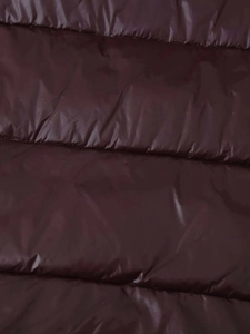 Detailaufnahme von dunkelweinrotem, horizontal gestepptem Stoff mit seidigem Glanzeffekt