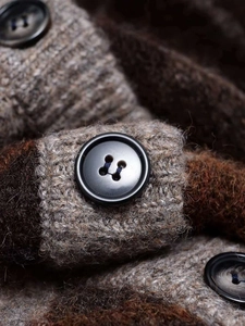 Detail of chunky knit sweater with textured brown mixed yarn and black resin buttons