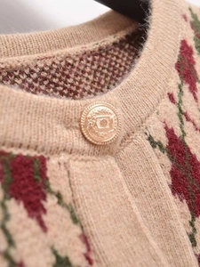 Close-up of diamond pattern knit cardigan with embossed gold vintage metal button
