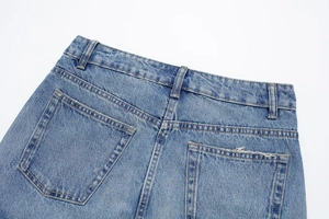 Détails du dos d'une jupe en jean bleu clair avec poches plaquées et effet délavé