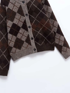 Detail of diamond pattern knit cardigan with five buttons and ribbed cuffs
