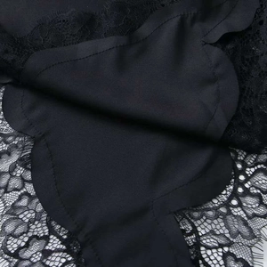 Detailed close-up of floral lace stitching and scalloped edges on a black summer dress