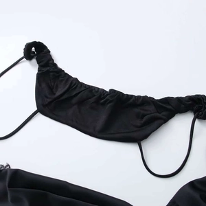 Detail of the black camisole showing pleated fabric and thin adjustable straps