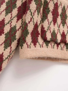 Detailed view of the fuzzy argyle knit fabric texture in beige, burgundy, and olive green