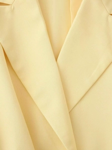 Gros plan d'un blazer jaune clair avec tissu en sergé de qualité et coutures raffinées