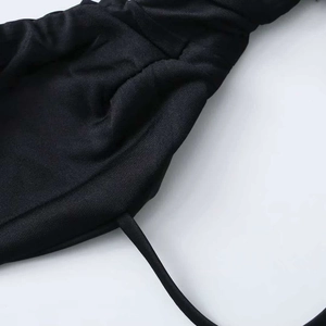 Macro shot of black elastic knit fabric featuring ruching details and a thin decorative drawstring