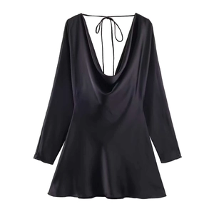 Détail d'une mini-robe en satin noir avec col bénitier drapé et texture soyeuse brillante