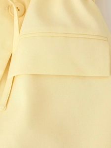Détail d'un blazer jaune clair montrant la texture du sergé et le rabat de la poche
