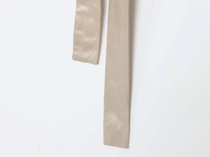 Detail of elegant champagne satin bow tie belt with smooth glossy silk texture
