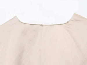 Detail of round neckline on beige cotton linen shirt with fine stitching craftsmanship