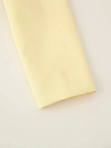 Vue macro de la manche du blazer jaune clair montrant la texture du tissu sergé et la couture