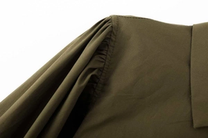 Vue détaillée d'une chemise vert olive foncé avec épaules plissées et structure de col classique