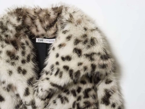 Detail of faux fur leopard print coat neckline and shoulder with brand size label