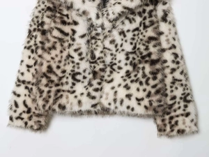 Close-up detail of luxury leopard print faux fur coat showing soft plush texture and pattern