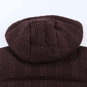 Detailed macro view of dark brown cable-knit texture on heavy hooded winter jacket