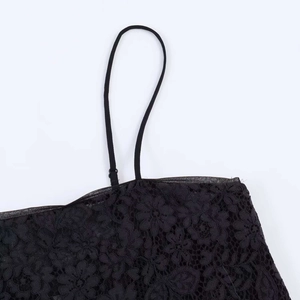 Detail of floral lace texture and adjustable thin shoulder straps on black camisole top