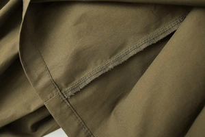 Gros plan détaillé des coutures intérieures et double piqûre sur tissu popeline olive