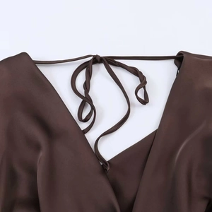 Détail de la robe en satin marron avec décolleté drapé et fines brides à nouer au dos