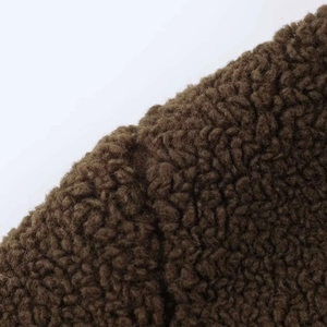 Close-up of deep brown fleece fabric showing thick curly texture for winter coats