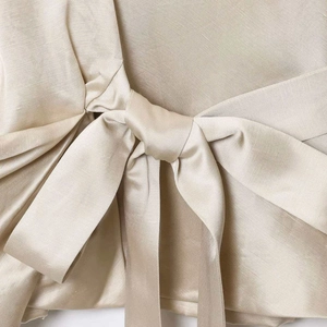Elegant champagne satin blouse for women featuring a stylish bow tie design and silk texture