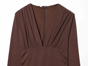 Close-up of deep V-neckline with ruched detailing on a brown satin texture dress