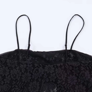 Close-up of black floral lace top featuring adjustable thin straps and mesh lining