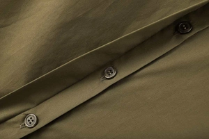 Détail de la patte de boutonnage d'une chemise en popeline olive avec trois boutons