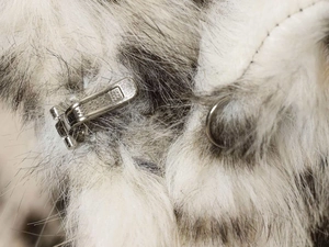 Detail of silver metal HOKB spring buckle on premium grey and white faux fur coat