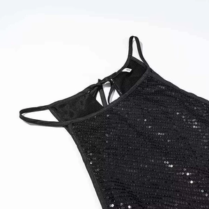 Detailed macro shot of black sequin fabric with silver glint and small S size label tag