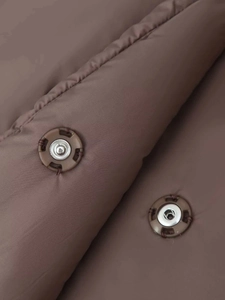 Detail of snap button closures and quilted fabric texture on dark brown puffer jacket