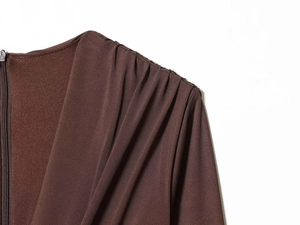Detailed macro view of gathered shoulder pleats and hidden zipper on chocolate satin dress