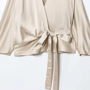 Champagne satin wrap blouse with long sleeves and elegant waist tie bow detail