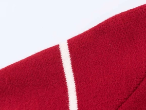 Close-up of red knit sweater fabric with white decorative stripes and soft texture