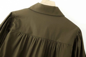 Détail du dos d'une chemise en popeline vert olive montrant les plis à l'épaule et le col