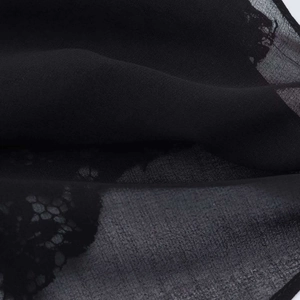 Detailed macro view of black semi-transparent lace fabric with floral jacquard texture