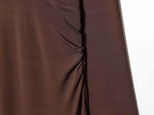 Detail of ruched side seams on a chocolate brown satin texture slim fit maxi dress