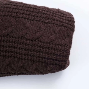 Detailed macro view of the dark brown chunky cable knit texture and ribbed cuff design