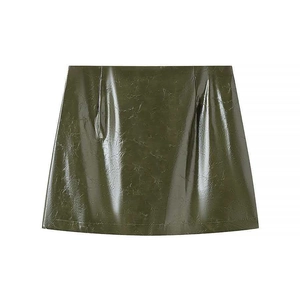 Detailed macro view of dark green glossy faux leather mini skirt with wrinkled texture