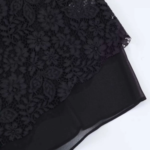 Detailed macro shot of vintage floral lace texture and layered chiffon fabric in black