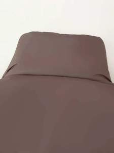 Close-up of overlapping brown fabric seams with soft satin finish on winter coat