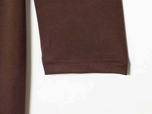 Detailed close-up of double-needle stitching and knit texture on dark brown satin dress
