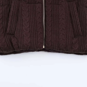 Detailed view of dark brown cable knit jacket with silver metal zipper and side pockets