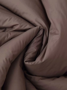 Close-up of deep brown quilted fabric with a subtle silky luster and soft texture